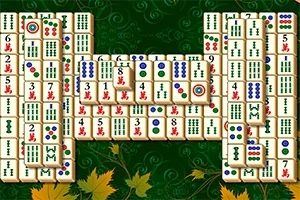Mahjong-brickor placerade i ett rektangulärt mönster på en grön bakgrund med lövdekorationer