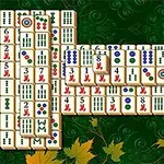 Mahjong-brickor placerade i ett rektangulärt mönster på en grön bakgrund med lövdekorationer