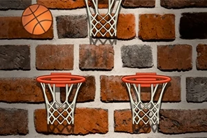 En tegelvägg med tre basketkorgar och en basketboll