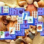 Brickor med olika strandmotiv placerade ovanpå sand och snäckor