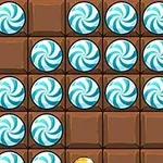 Bruna chokladrutor med blå spiralformade godisbitar på ett spelbräde