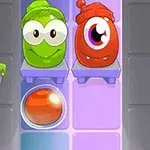 Två tecknade figurer, en grön och en röd, med stora ögon, står på hyllor över en glödande orange boll i en färgglad bakgrund