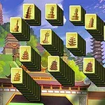 Mahjongbrickor med pagodmotiv arrangerade mot en bakgrund av ett asiatiskt landskap med tempel och körsbärsblommor