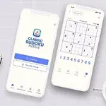 Två smartphones på ett bord med en anteckningsbok, en växt och ett litet väckarklocka, där den ena telefonen visar en öppningsskärm för en app och den andra visar ett spelpussel