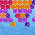 Färgade bollar i rött, orange, lila, och blått mot en blå bakgrund