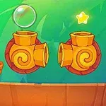 En grön figur sitter på en orange plattform bredvid två orange kanontunnlar på en färgglad bakgrund med två stjärnor och en bubbla