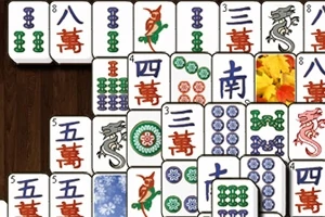 Mahjong-brickor med olika symboler och färger arrangerade på en träyta