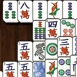 Mahjong-brickor med olika symboler och färger arrangerade på en träyta