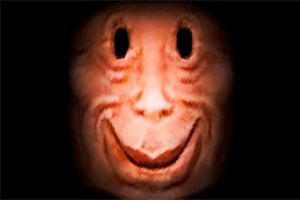 Ett ansikte med ett brett leende och håligheter där ögonen skulle vara, mot en mörk bakgrund
