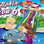 Två personer i våtdräkter sitter vid en pool med en delfin, omgivna av vattenrutschbanor och palmer i bakgrunden