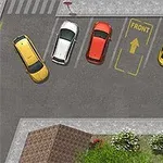 Flera färgade bilar parkerade på en parkeringsplats nära grönska och en gångväg