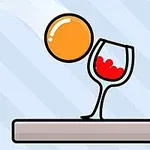 En orange boll faller mot ett vinglas med röd vätska på ett brunt underlag