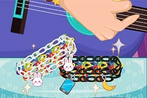 En hand spelar gitarr medan två färgglada armband med olika berlocker ligger i förgrunden