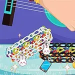 En hand spelar gitarr medan två färgglada armband med olika berlocker ligger i förgrunden