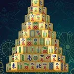 En pyramidformad stapel av mahjong-brickor mot en mörkblå bakgrund med blommönster