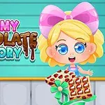 Tecknad flicka med stor rosett håller en chokladlåda framför en bakgrund med texten Yummy Chocolate Factory