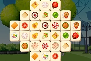 Kakel med olika matbilder som kex, godis och frukt, arrangerade i ett rutnät mot en utomhusbakgrund